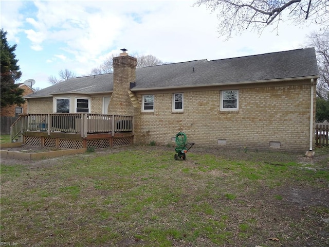 rear view of property featuring a lawn, a wooden deck, crawl space, brick siding, and a chimney