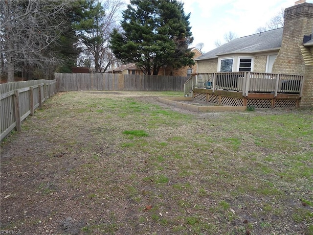 view of yard with a wooden deck and a fenced backyard