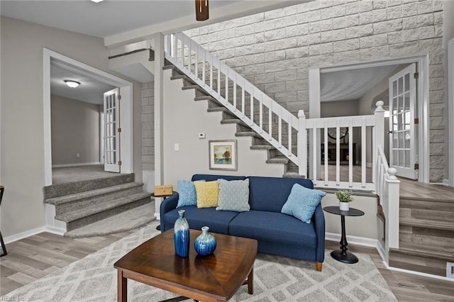 living area featuring stairs, baseboards, and wood finished floors