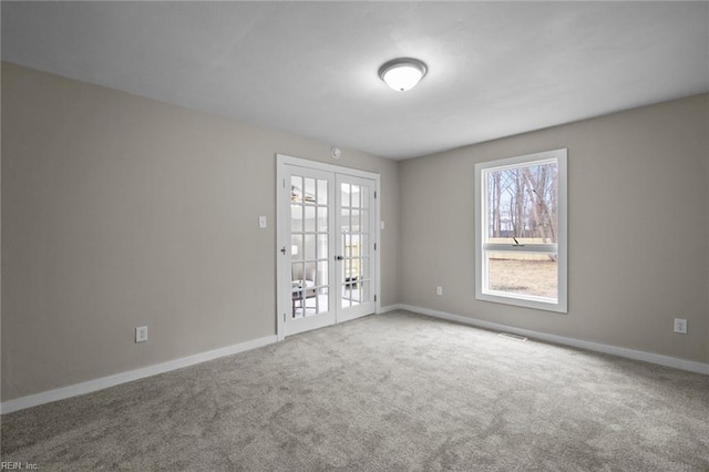 carpeted empty room featuring visible vents, french doors, and baseboards