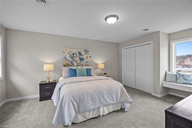 carpeted bedroom with a closet, baseboards, and visible vents