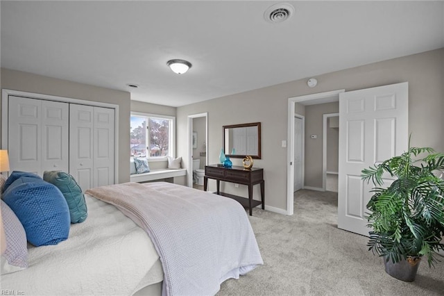 bedroom featuring a closet, visible vents, light colored carpet, and baseboards