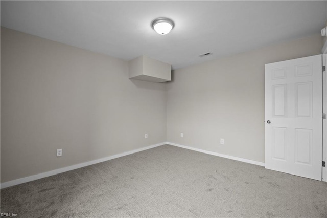 carpeted empty room featuring baseboards and visible vents