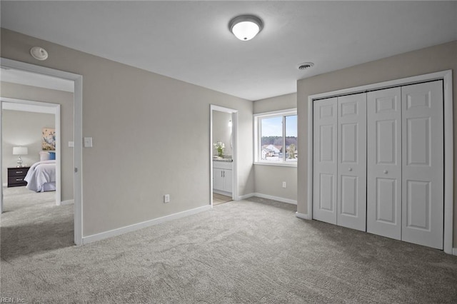 unfurnished bedroom featuring a closet, visible vents, baseboards, and carpet floors