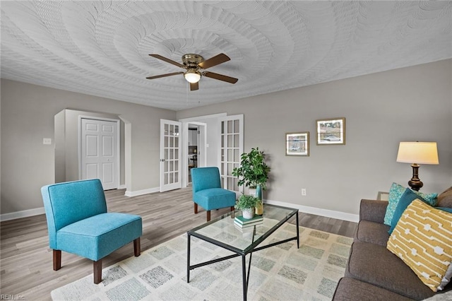 living room featuring wood finished floors, french doors, baseboards, and ceiling fan