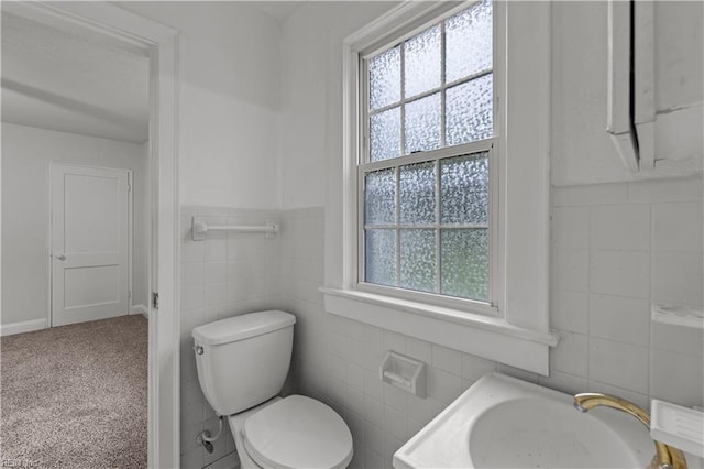 bathroom with toilet and tile walls