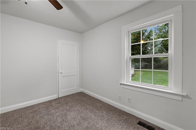 carpeted empty room with a ceiling fan, visible vents, and baseboards