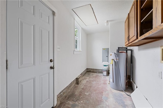 laundry area featuring gas water heater, attic access, and a textured ceiling