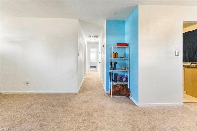 interior space featuring baseboards, visible vents, and light carpet