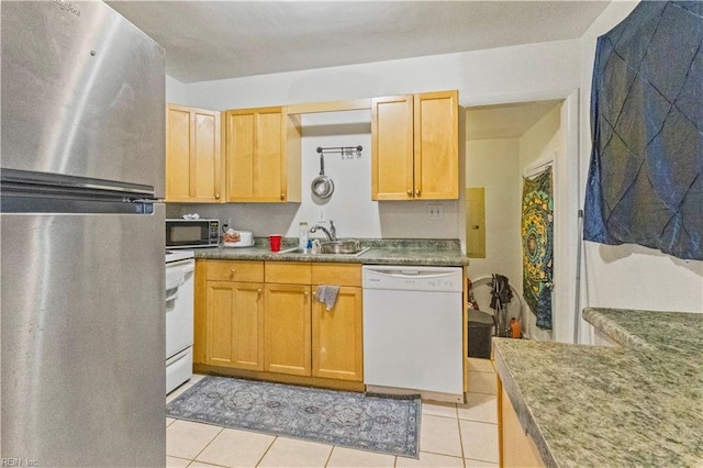 kitchen with dishwasher, freestanding refrigerator, light tile patterned flooring, stove, and a sink