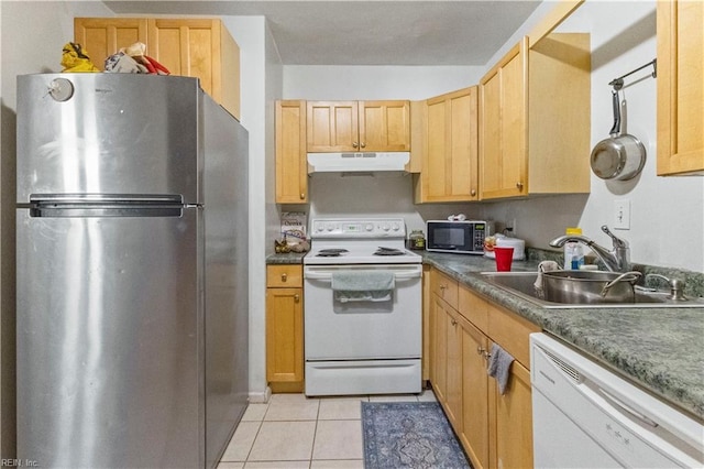 kitchen with white appliances, light tile patterned flooring, a sink, under cabinet range hood, and dark countertops