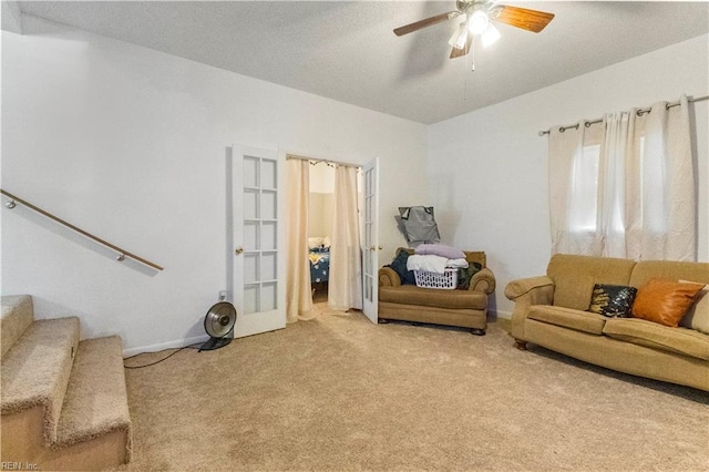 living room with a ceiling fan, stairway, carpet, and french doors