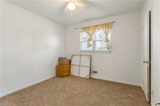 spare room with light carpet, visible vents, baseboards, and ceiling fan