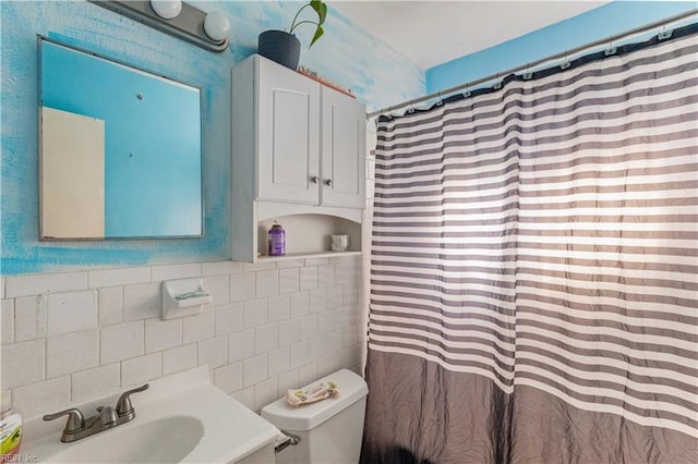 full bathroom with a shower with shower curtain, tile walls, toilet, and a sink