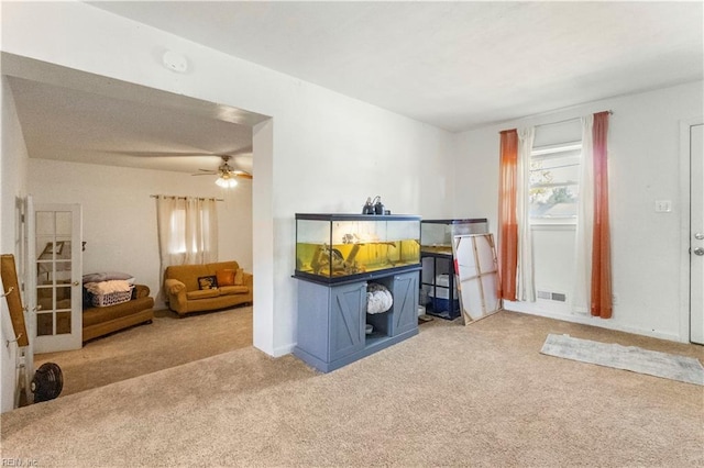 interior space with visible vents, a ceiling fan, and carpet floors