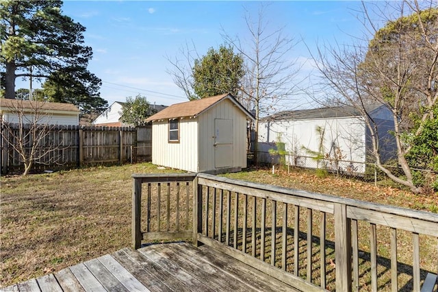 wooden deck featuring a fenced backyard, a shed, and an outdoor structure