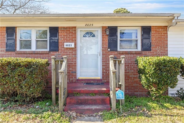 entrance to property featuring brick siding