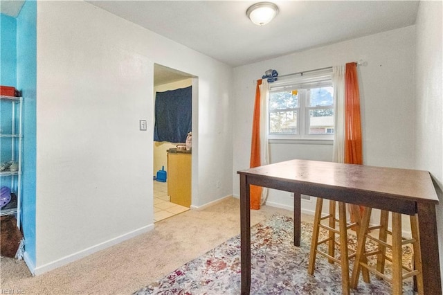 dining area with light colored carpet and baseboards