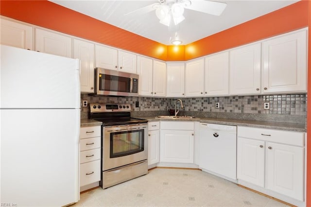 kitchen with decorative backsplash, white cabinets, appliances with stainless steel finishes, and a sink