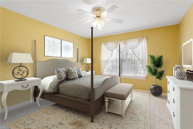 carpeted bedroom featuring ceiling fan, baseboards, and a textured ceiling