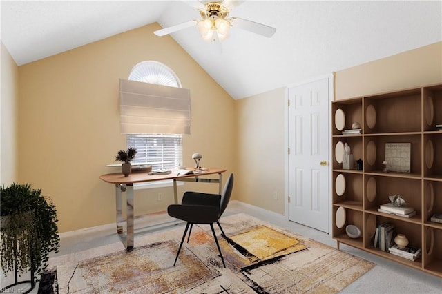 carpeted office featuring vaulted ceiling, a ceiling fan, and baseboards