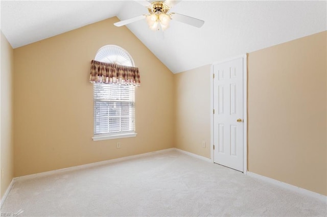 spare room with baseboards, light carpet, lofted ceiling, and ceiling fan