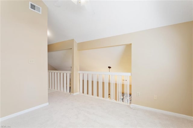 interior space with vaulted ceiling, baseboards, visible vents, and carpet floors