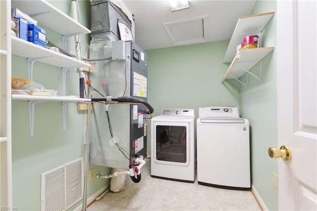 clothes washing area featuring visible vents, baseboards, washing machine and dryer, attic access, and laundry area