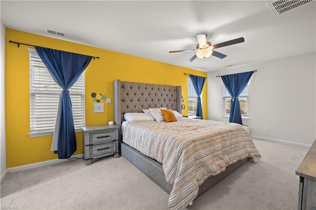 carpeted bedroom with visible vents, a ceiling fan, and baseboards