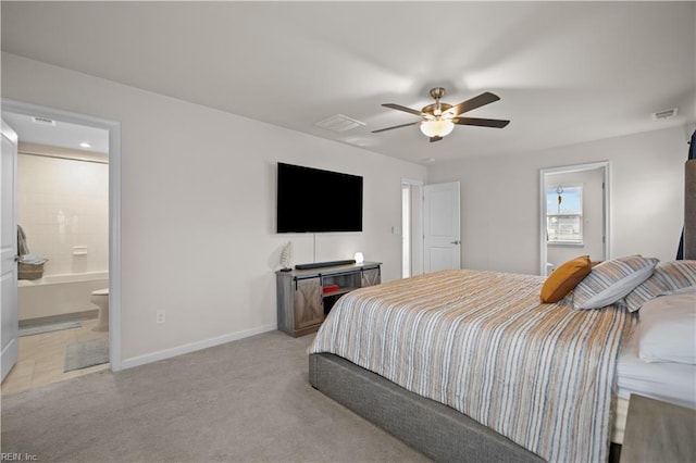 bedroom featuring ensuite bath, light colored carpet, visible vents, and baseboards