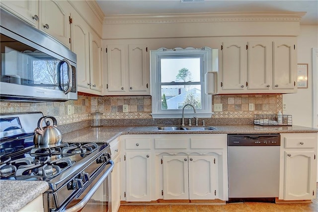 kitchen with a sink, backsplash, appliances with stainless steel finishes, white cabinets, and crown molding