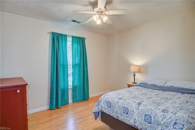 bedroom featuring visible vents, baseboards, wood finished floors, and a ceiling fan