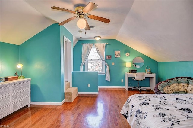 bedroom featuring ceiling fan, hardwood / wood-style flooring, baseboards, and vaulted ceiling