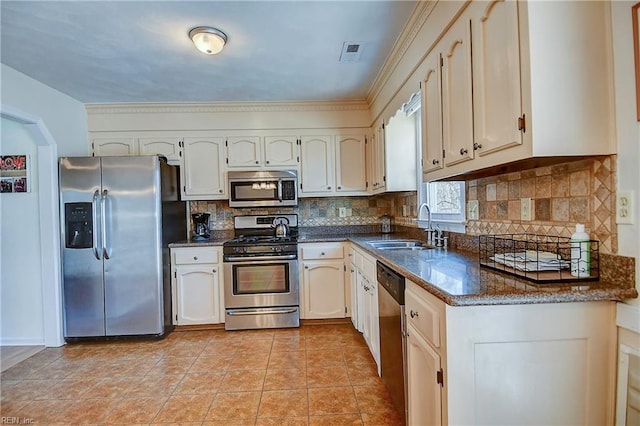 kitchen with visible vents, light tile patterned floors, decorative backsplash, stainless steel appliances, and a sink