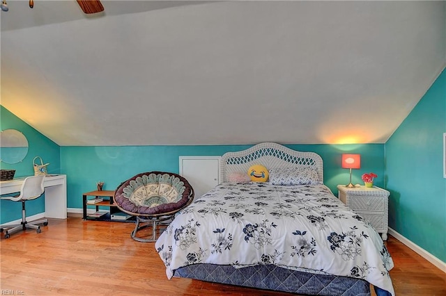 bedroom with lofted ceiling, baseboards, and wood finished floors