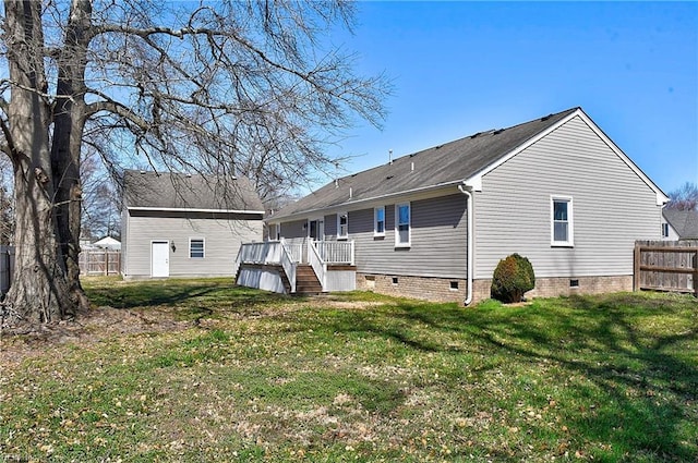 rear view of property featuring crawl space, a lawn, and fence