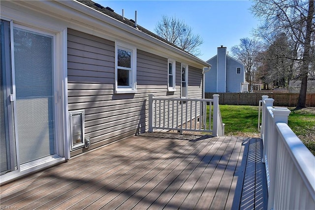 wooden deck featuring a yard and fence