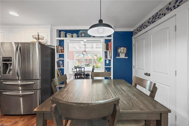 dining space with dark wood-type flooring and ornamental molding