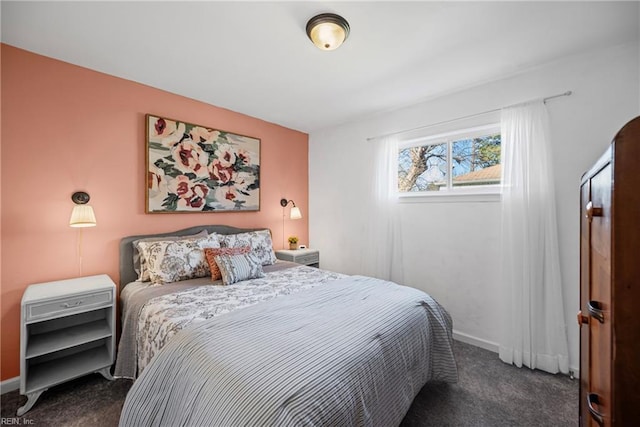 bedroom featuring dark carpet and baseboards