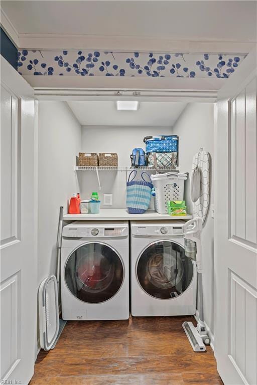 laundry area featuring wood finished floors, laundry area, and washer and clothes dryer