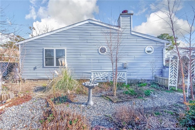 view of side of home featuring a chimney and crawl space