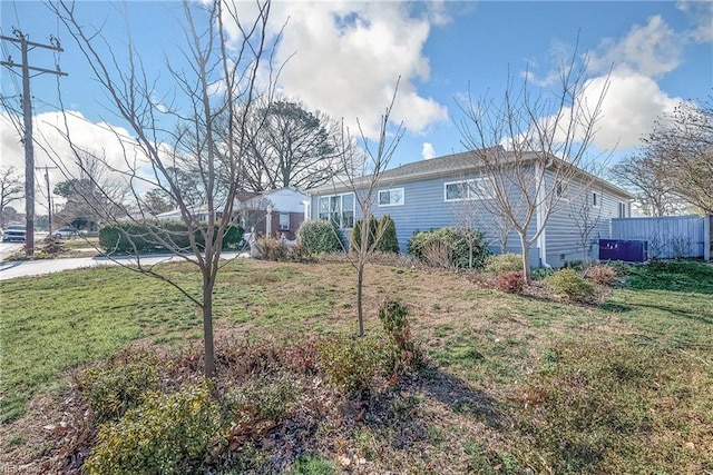 view of front of home with crawl space, a front lawn, and fence