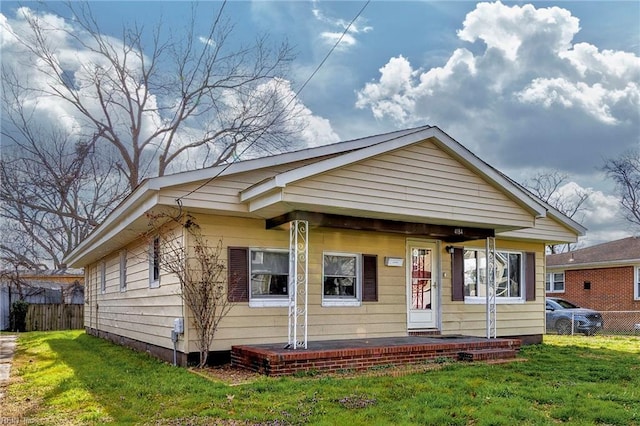 bungalow-style house featuring a front lawn and fence