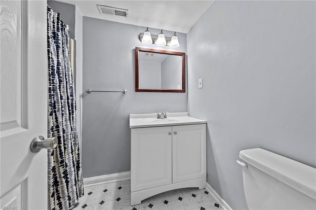 bathroom featuring visible vents, toilet, vanity, and baseboards