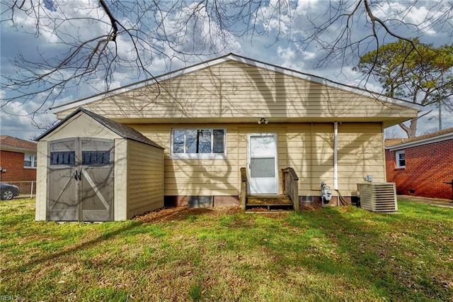 back of house featuring a lawn, entry steps, a storage shed, an outdoor structure, and central AC unit