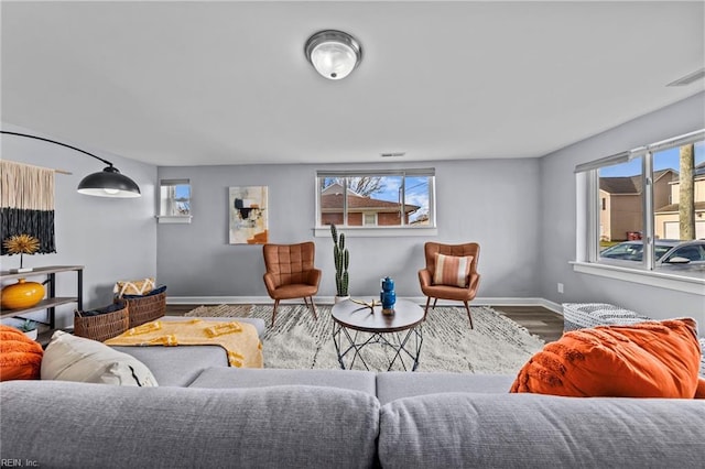 living room with visible vents, wood finished floors, and baseboards