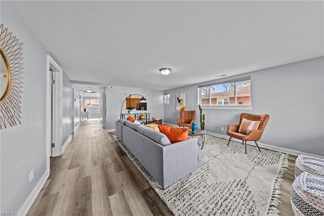 living area featuring baseboards and wood finished floors