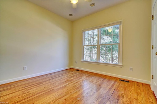 spare room with visible vents, baseboards, wood finished floors, and a ceiling fan