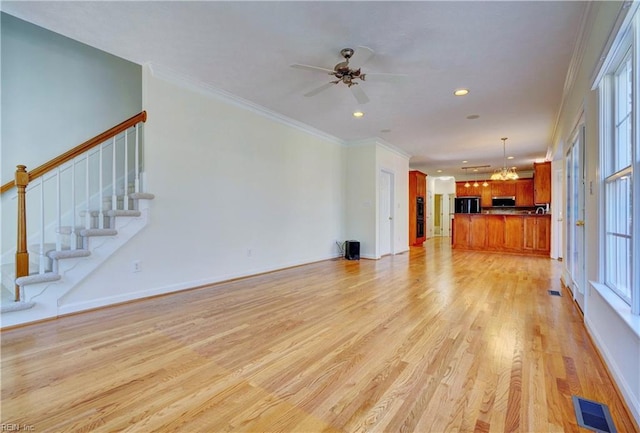 unfurnished living room with stairs, light wood-style floors, visible vents, and ornamental molding