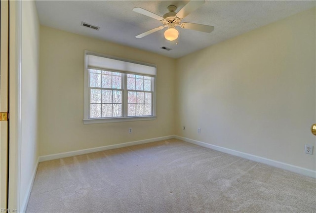 empty room featuring visible vents, ceiling fan, baseboards, carpet, and a textured ceiling